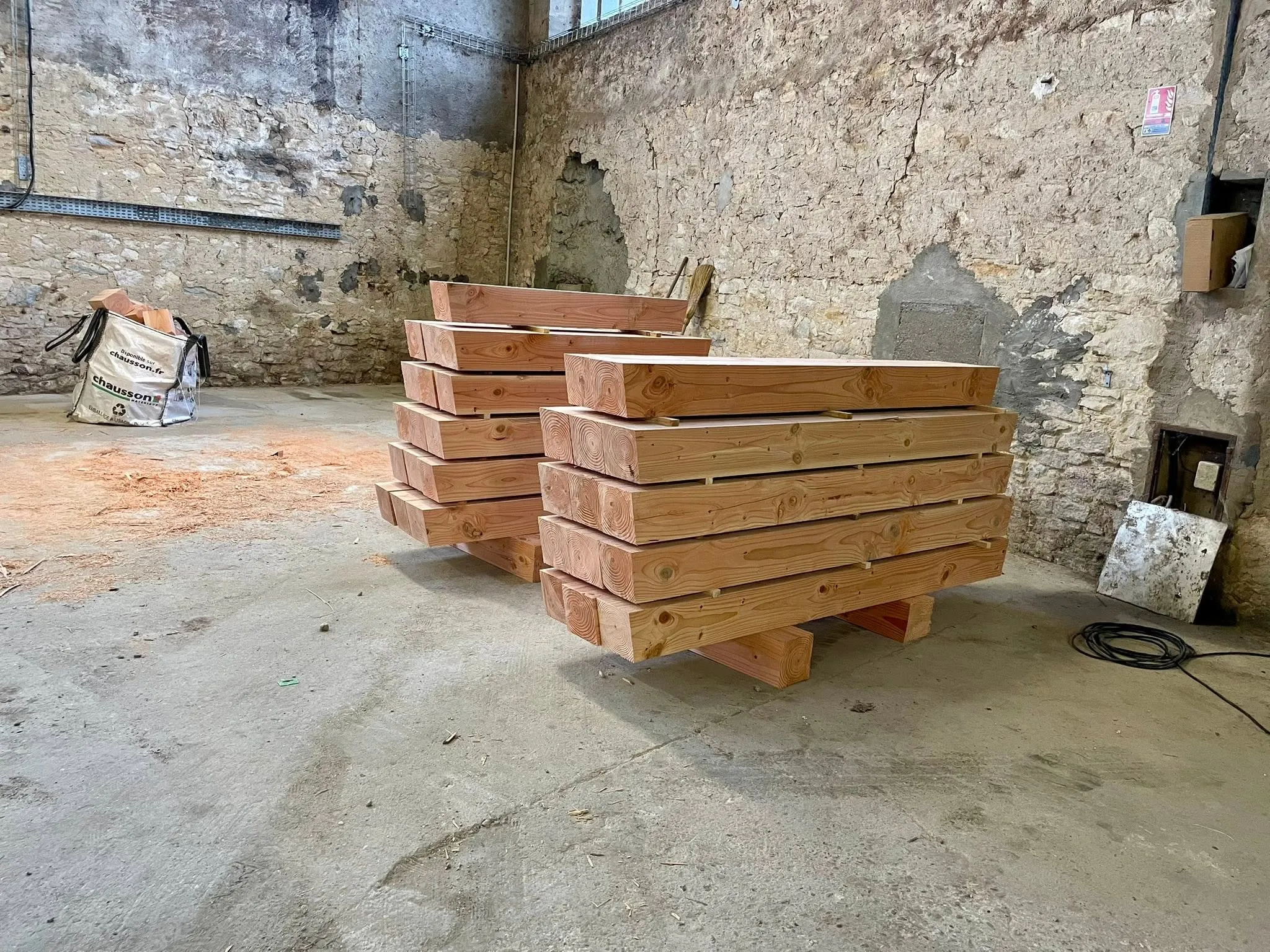 Solives taillées et empilées dans l’atelier pour le second plancher à la française à Blaye